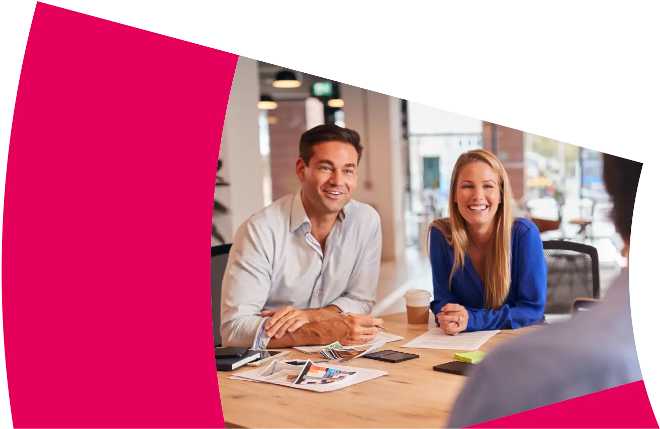 A team meeting to discuss company accounts in a large open plan office.